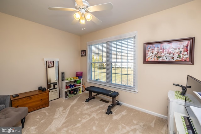 workout area with baseboards, ceiling fan, and carpet flooring