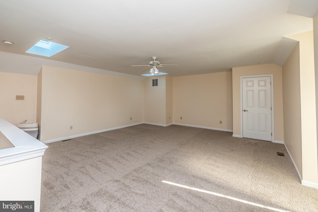 unfurnished living room featuring a ceiling fan, visible vents, carpet floors, and baseboards