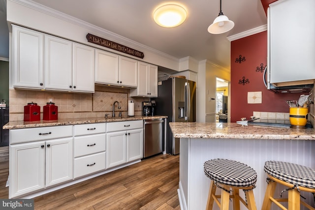 kitchen with white cabinetry, crown molding, wood finished floors, and stainless steel appliances