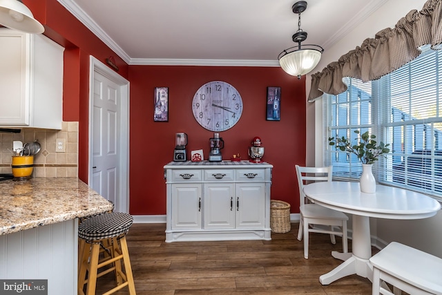 dining space with dark wood-style floors, baseboards, and ornamental molding