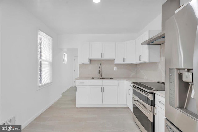 kitchen with a sink, tasteful backsplash, appliances with stainless steel finishes, and light countertops