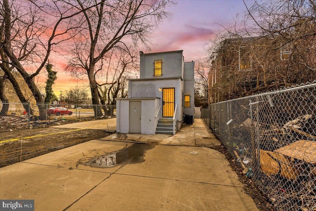 exterior space with entry steps, central AC unit, and fence