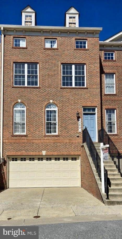 view of front of house featuring a garage, brick siding, and driveway