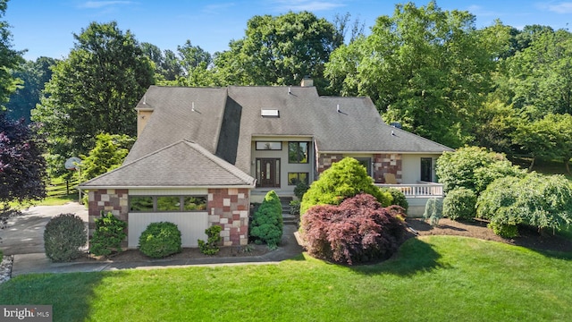 view of front of house featuring a front yard, stone siding, and a shingled roof