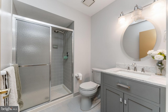 full bathroom featuring vanity, a shower stall, toilet, and tile patterned floors