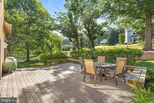 wooden deck featuring outdoor dining area, grilling area, and fence