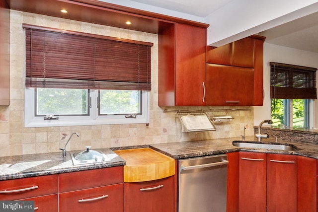 kitchen with dark stone counters, plenty of natural light, tasteful backsplash, and a sink