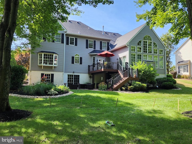 rear view of house with stairs, a lawn, and a wooden deck