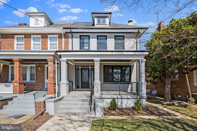 traditional style home featuring a porch and brick siding