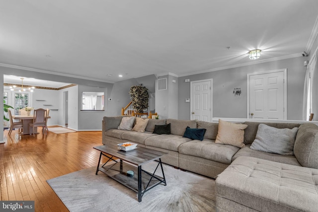 living room featuring hardwood / wood-style floors, stairs, baseboards, and ornamental molding