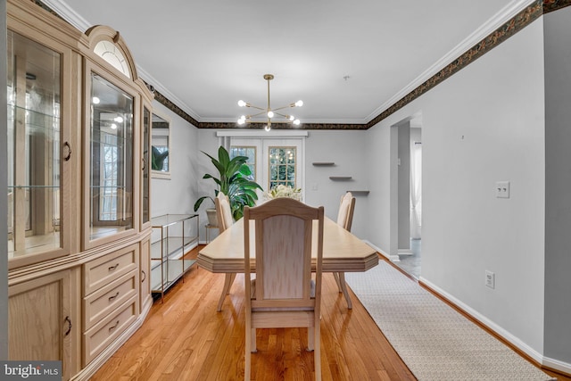 dining space featuring a notable chandelier, baseboards, crown molding, and light wood-style floors