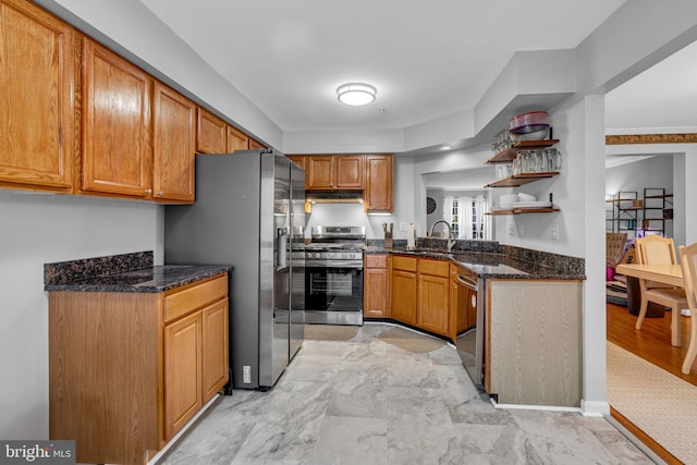 kitchen featuring a sink, open shelves, dark stone countertops, appliances with stainless steel finishes, and brown cabinetry