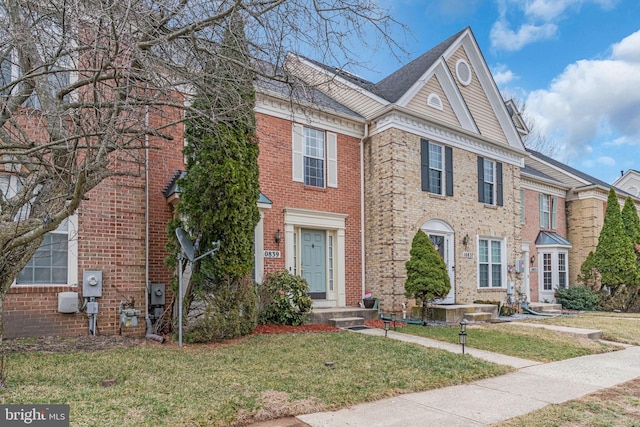 view of front facade featuring brick siding and a front yard