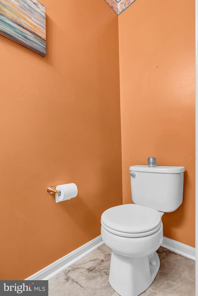 bathroom with baseboards and toilet