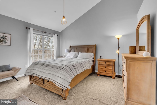 bedroom with lofted ceiling, baseboards, and light carpet