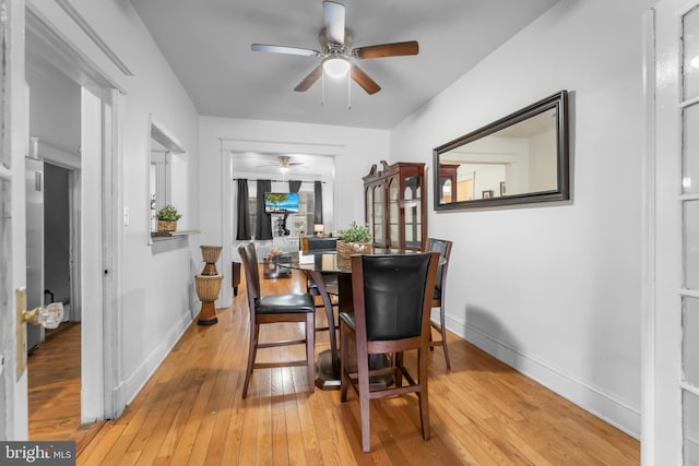 dining room featuring a ceiling fan, baseboards, and wood-type flooring