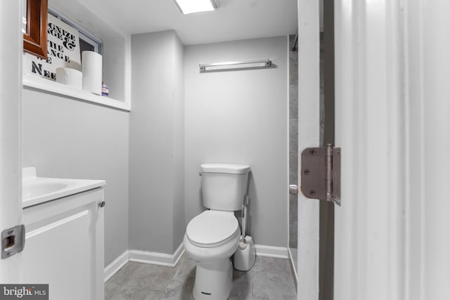 bathroom with vanity, toilet, and baseboards