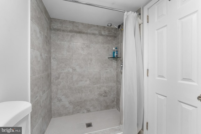 bathroom with toilet and a stall shower