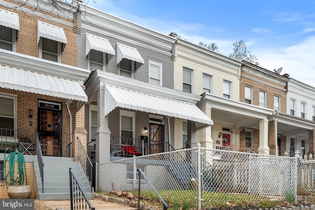 view of property with brick siding and a fenced front yard