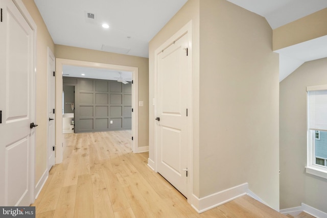 corridor featuring visible vents, light wood-style floors, and baseboards