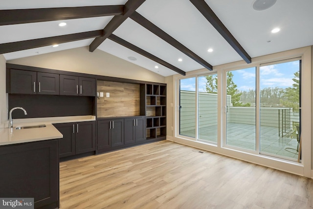 interior space featuring lofted ceiling with beams, recessed lighting, a sink, light countertops, and light wood-type flooring