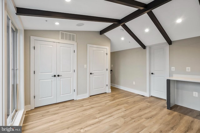 interior space with lofted ceiling with beams, baseboards, visible vents, and light wood-type flooring