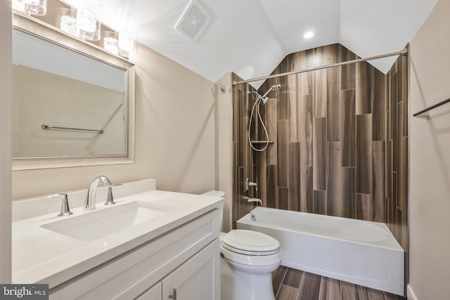 bathroom featuring visible vents, washtub / shower combination, toilet, wood finished floors, and vanity