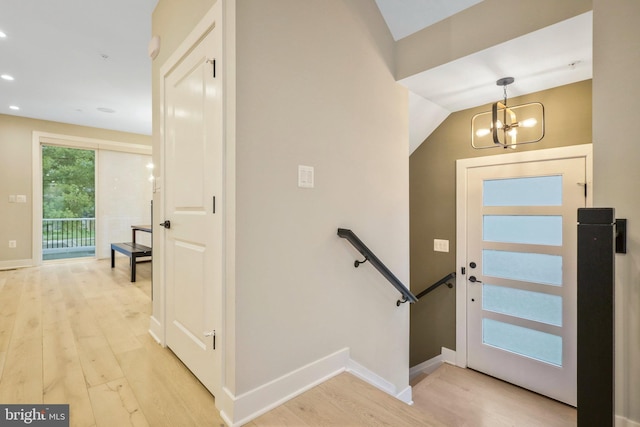 entrance foyer featuring recessed lighting, an inviting chandelier, baseboards, and light wood-style floors