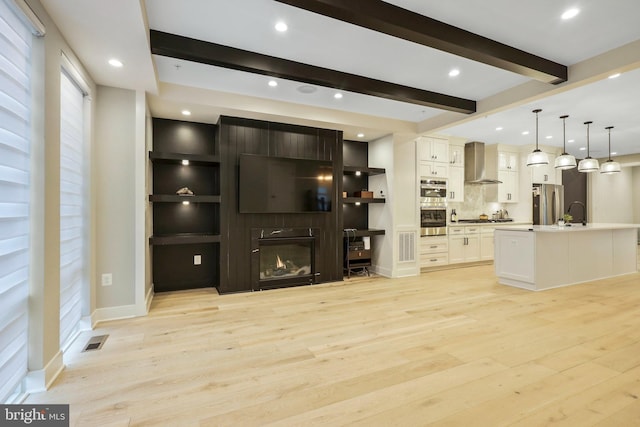 living room with visible vents, a large fireplace, beamed ceiling, recessed lighting, and light wood-style floors