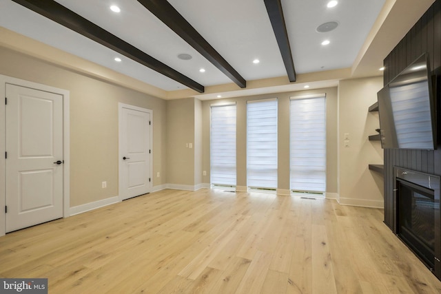 unfurnished living room with beamed ceiling, a fireplace, light wood-style floors, and baseboards