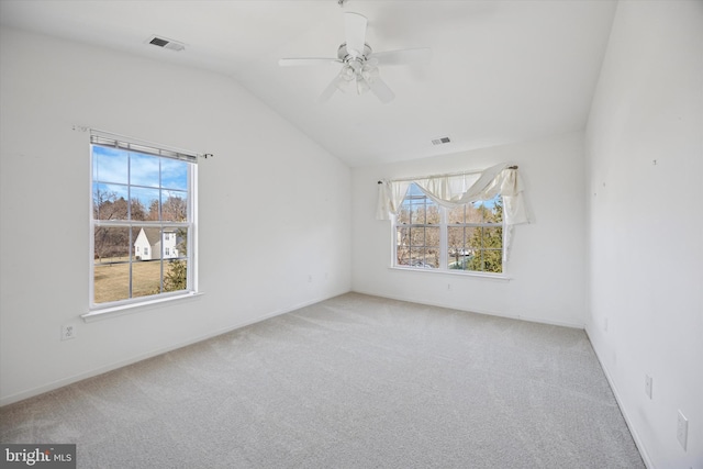 carpeted empty room featuring lofted ceiling, baseboards, visible vents, and ceiling fan