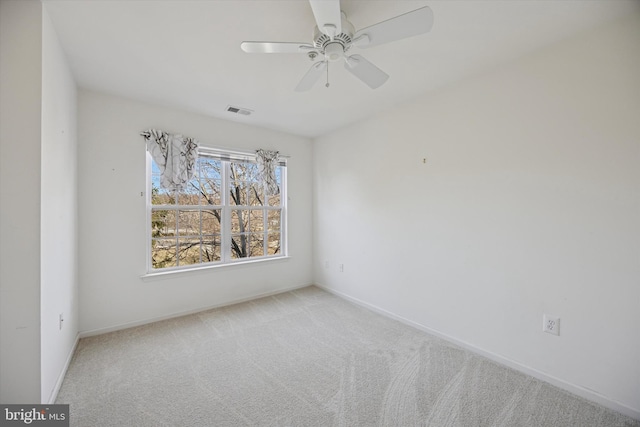 carpeted empty room with visible vents, ceiling fan, and baseboards