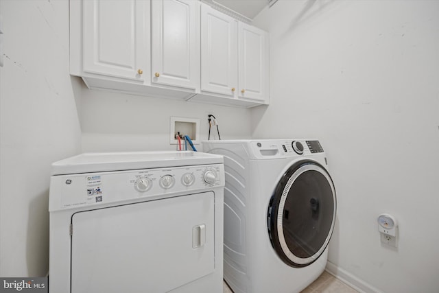 laundry area featuring baseboards, cabinet space, and independent washer and dryer