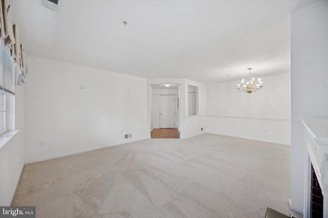 unfurnished living room featuring visible vents, carpet floors, and a chandelier