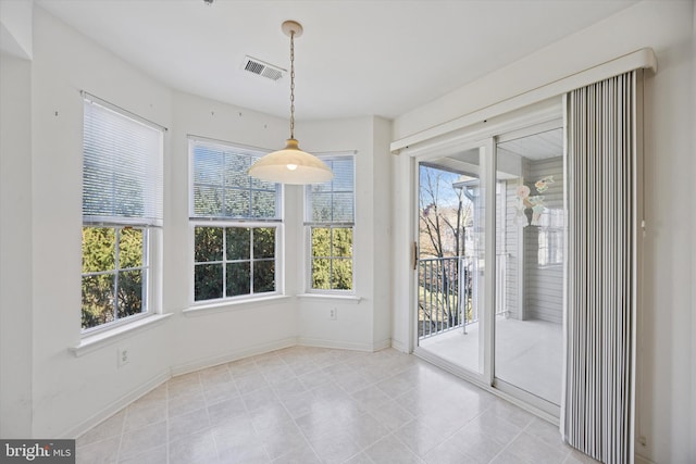 unfurnished dining area with baseboards and visible vents