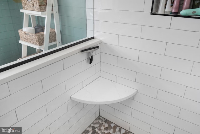 bathroom featuring tile walls and a tile shower