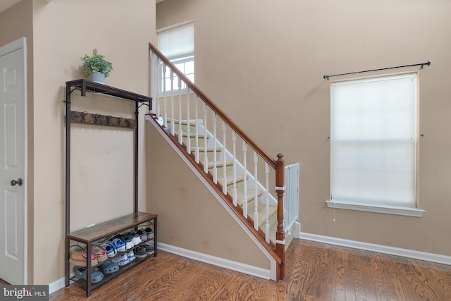 staircase featuring baseboards and wood finished floors