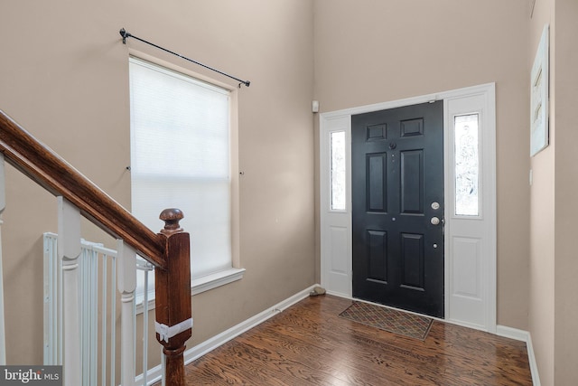 entryway featuring stairway, baseboards, and wood finished floors