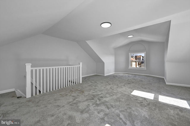 additional living space with baseboards and vaulted ceiling