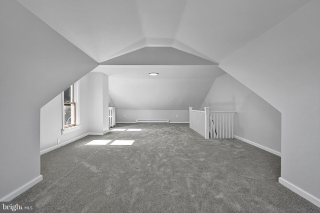 additional living space featuring vaulted ceiling, baseboards, and a baseboard radiator