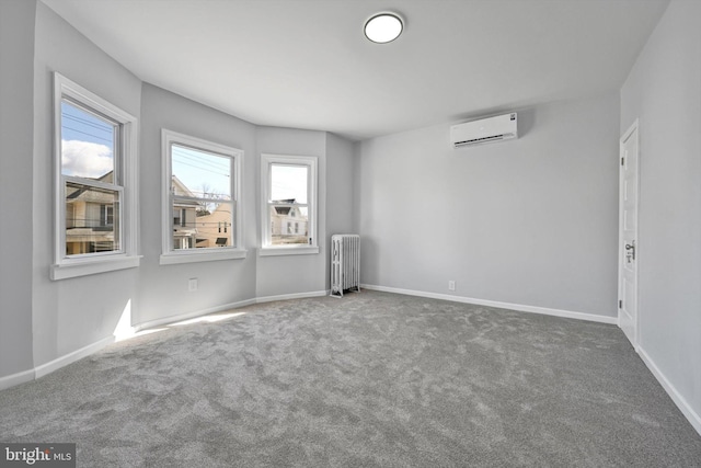 carpeted spare room featuring plenty of natural light, radiator, baseboards, and a wall unit AC