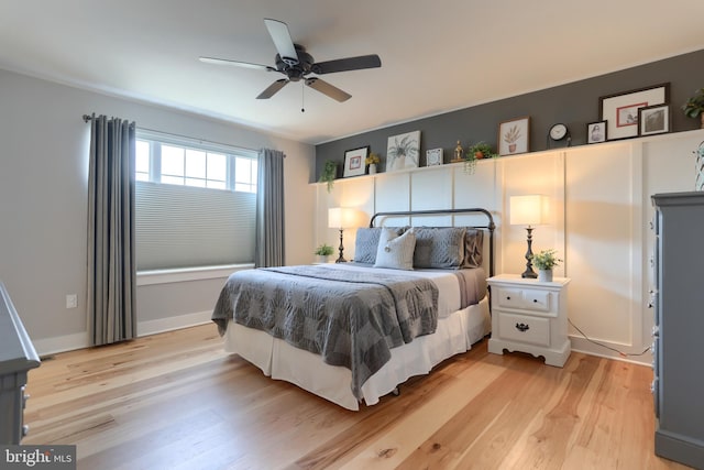 bedroom featuring baseboards, light wood-style floors, and ceiling fan