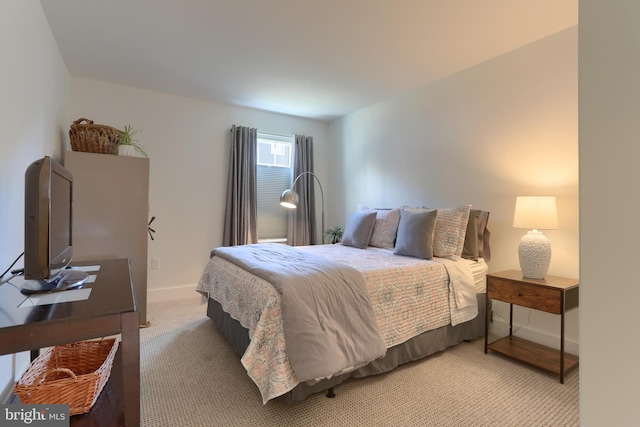 bedroom with baseboards and light carpet