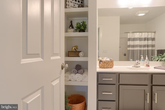 bathroom with a shower with shower curtain, built in shelves, and vanity