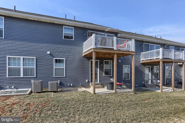 back of property featuring entry steps, a patio, and a lawn