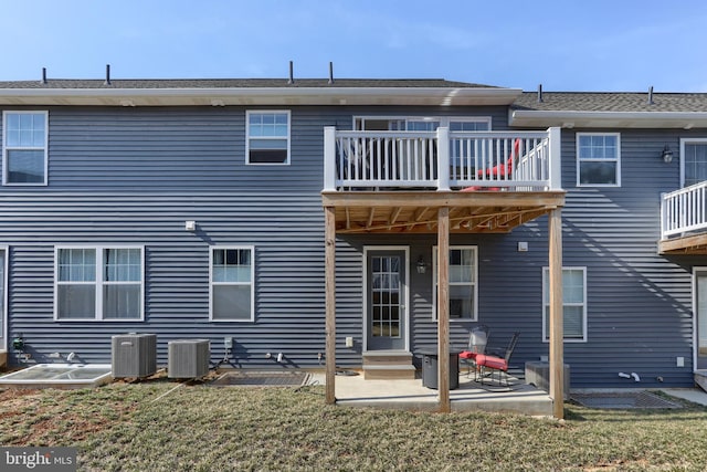 back of house with central AC unit, entry steps, a lawn, and a patio