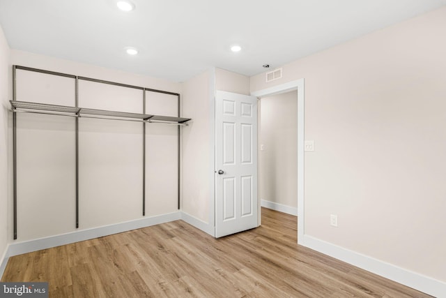 unfurnished bedroom featuring baseboards, visible vents, light wood finished floors, recessed lighting, and a closet