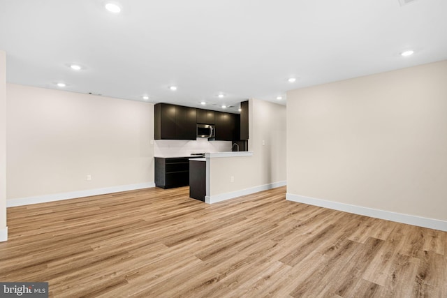 unfurnished living room featuring recessed lighting, light wood-type flooring, and baseboards