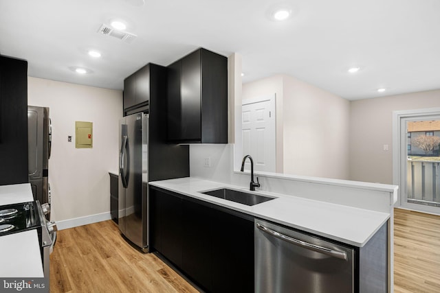 kitchen featuring visible vents, light countertops, dark cabinetry, stainless steel appliances, and a sink