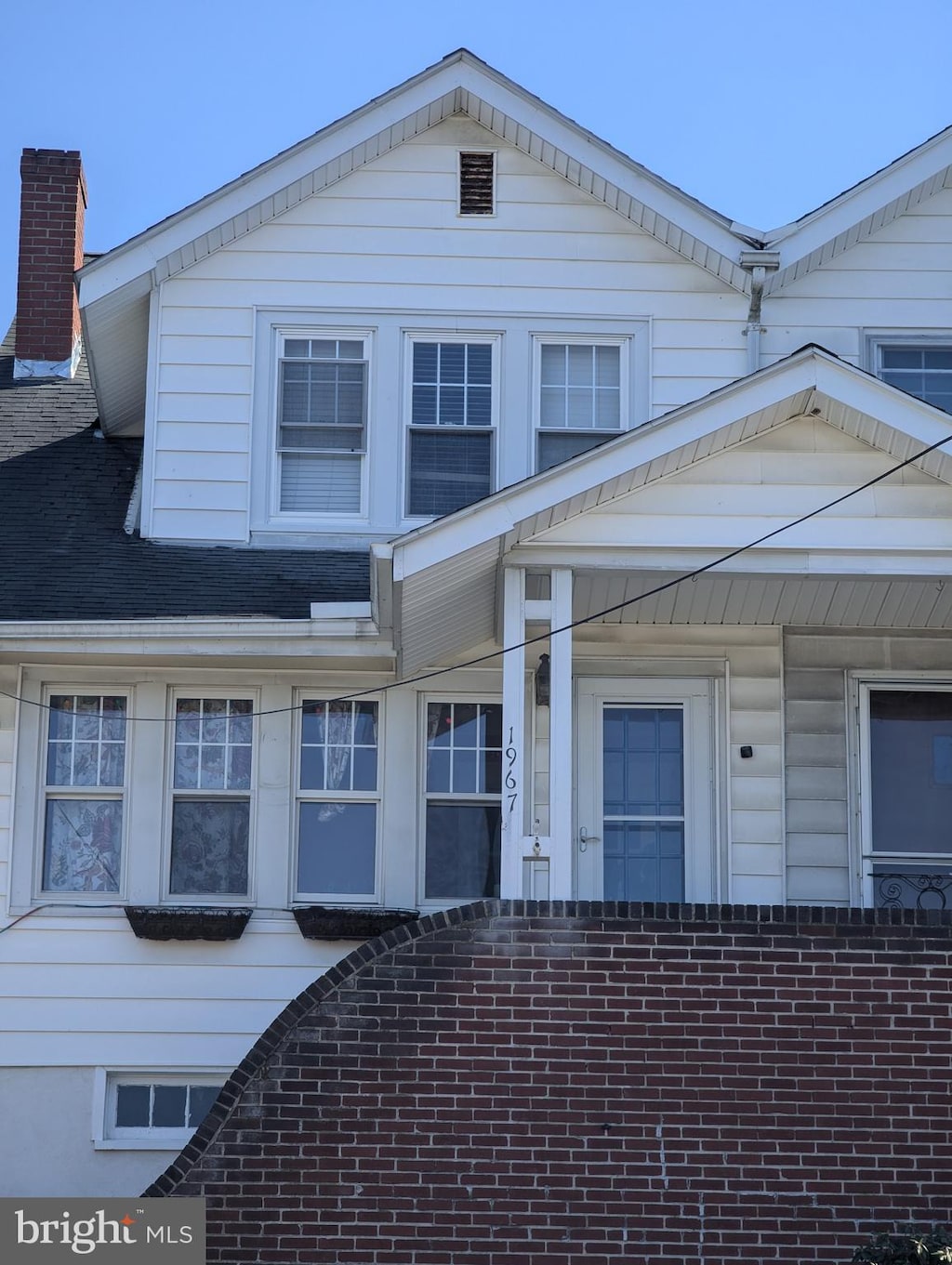 view of front of house featuring brick siding and a chimney